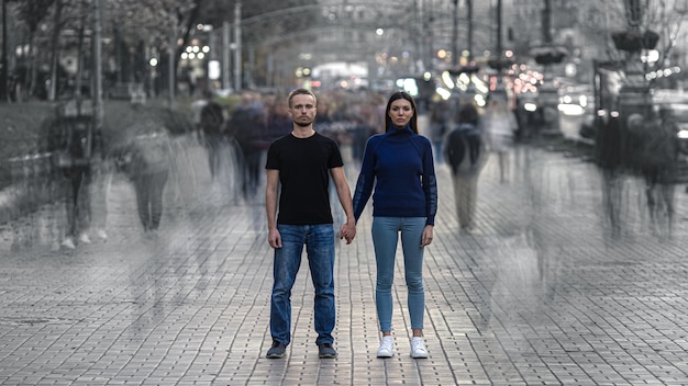 El hombre y la mujer se paran en la calle llena de gente y se dan la mano.