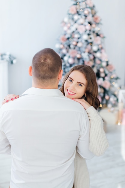 Hombre y mujer de pie cerca del árbol de Navidad