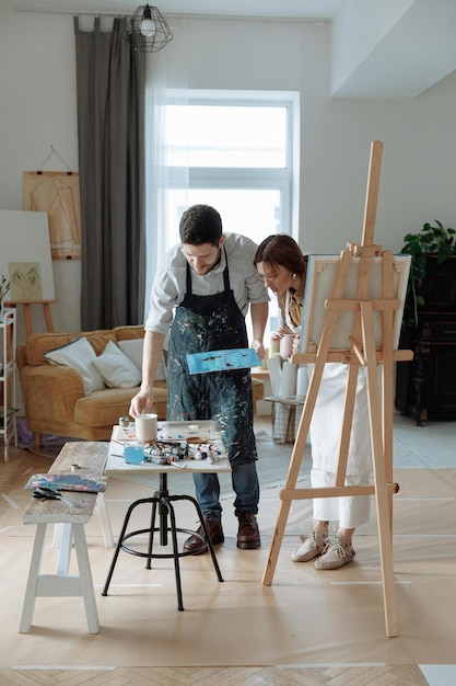 Hombre y mujer pintando en la mesa Foto de archivo