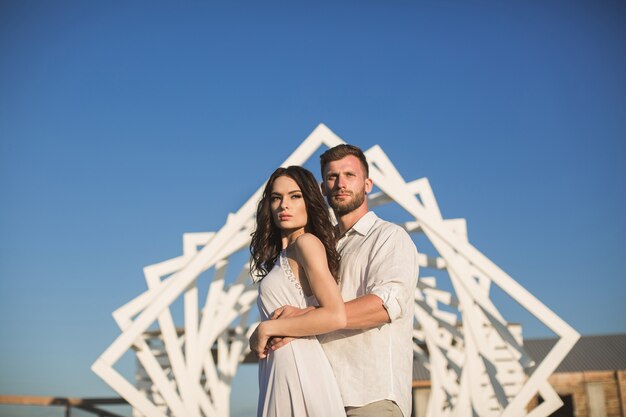 Hombre y mujer posando. Estructuras de madera geométricas. La novia y el novio.