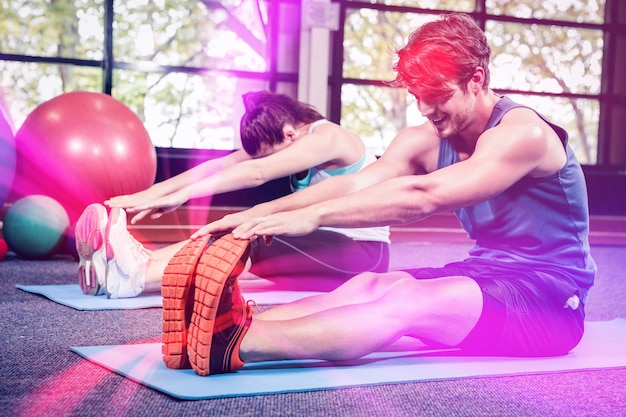 Hombre y mujer realizando ejercicio físico en el gimnasio