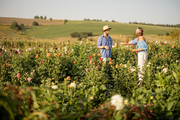 Hombre y mujer recogen flores en la granja al aire libre