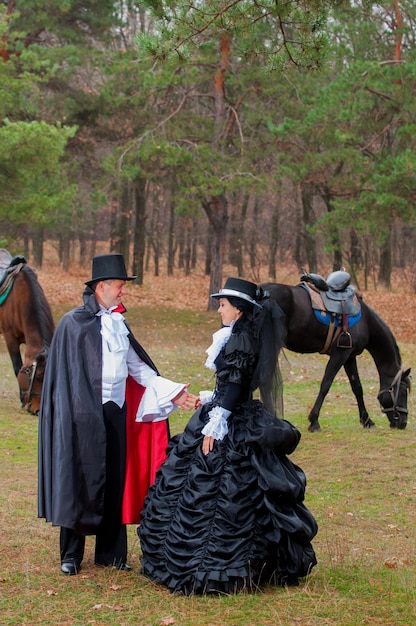 Un hombre, una mujer con ropa vieja y caballos.