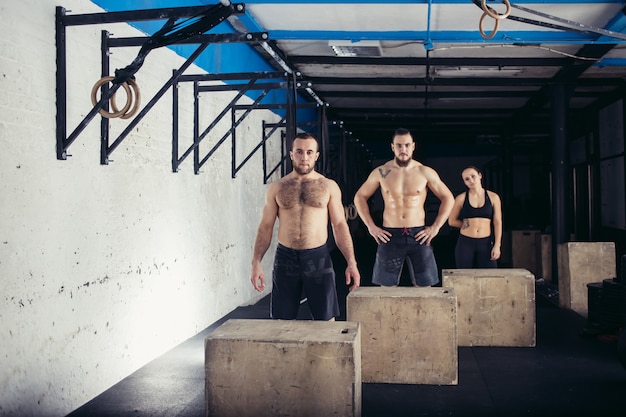 Hombre y mujer saltando sobre fit box en el gimnasio