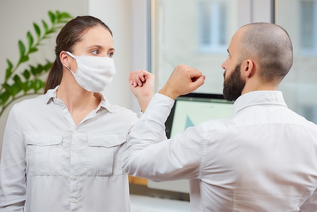 Foto hombre y mujer saludando en una oficina