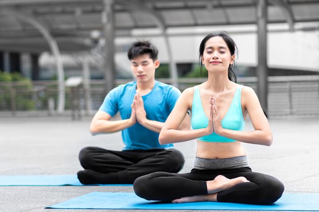 Hombre y mujer sanos ejercicio de yoga clase de yoga de salud ejercicio deportivo en estera de yoga fitness