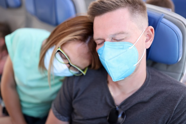 El hombre y la mujer se sientan en el asiento usan máscara protectora y duermen