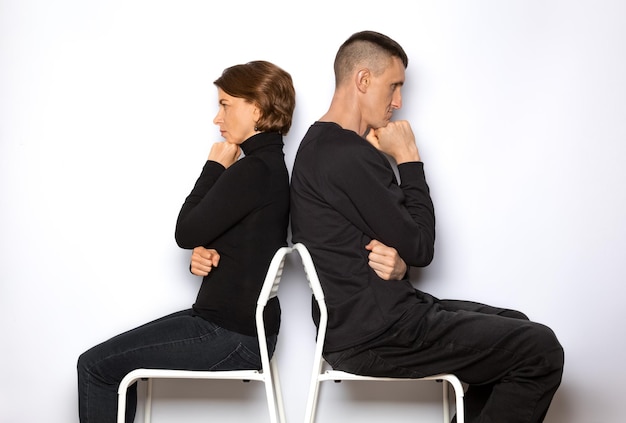 Un hombre y una mujer se sientan de espaldas.