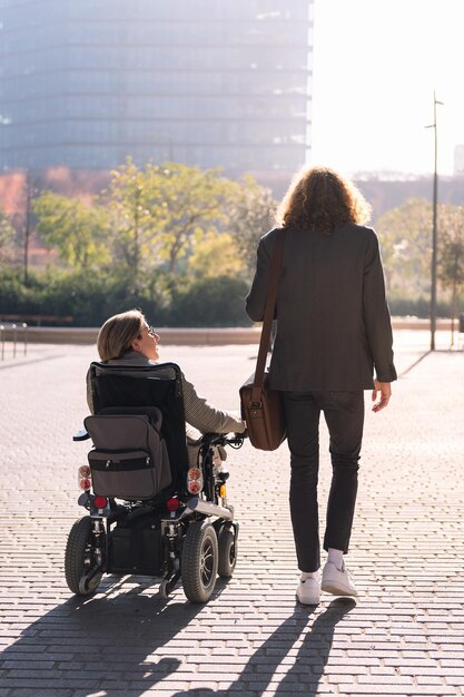 Hombre y mujer en silla de ruedas caminando por la ciudad