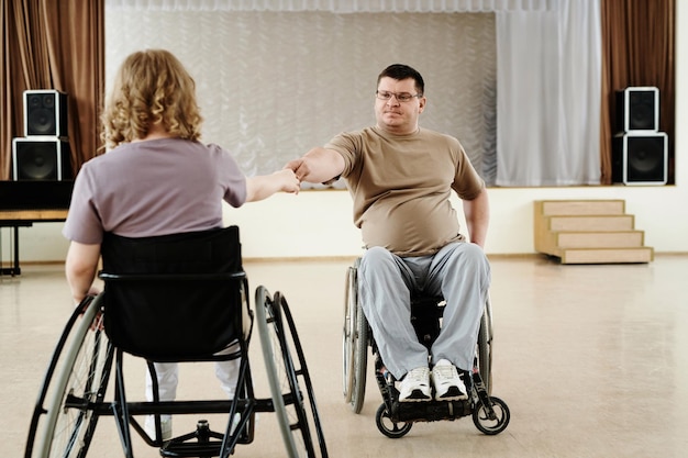 Hombre y mujer en sillas de ruedas bailando