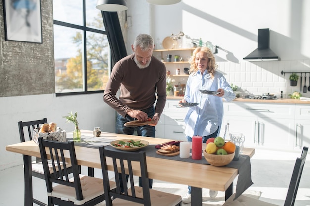 Hombre y mujer sirviendo la mesa para cenar