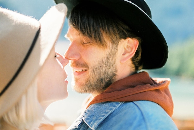 Hombre y mujer con sombreros se tocan las narices Retrato