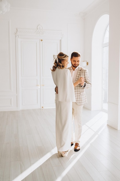 hombre y mujer en trajes de boda el día de la boda juntos en un interior luminoso