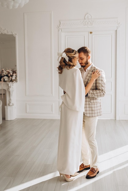 hombre y mujer en trajes de boda el día de la boda juntos en un interior luminoso