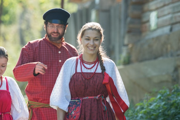 Hombre y mujer en trajes típicos rusos en celebración de la naturaleza