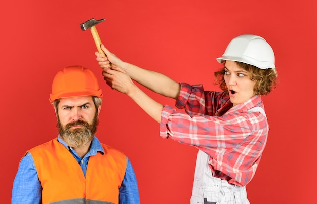 Hombre y mujer usan casco de seguridad pareja en el sitio de construcción pareja haciendo reparaciones en su casa