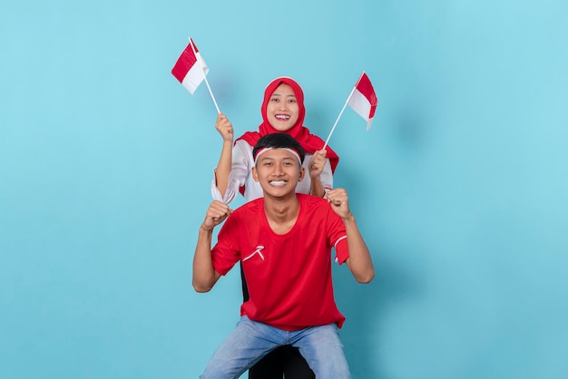 Hombre y mujer vestidos con atributos rojos y blancos emocionados de celebrar el día de la independencia de indonesia