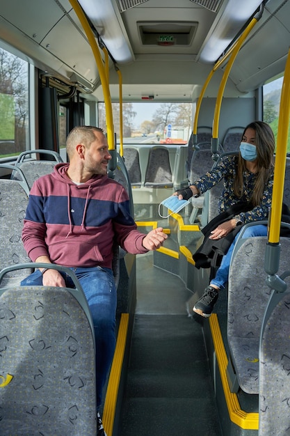 Foto hombre y mujer viajan al autobús con una máscara