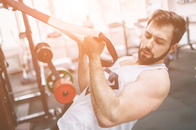 Hombre musculoso con barba durante el entrenamiento en el gimnasio