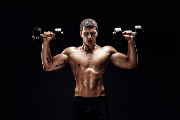 Hombre musculoso concentrado haciendo ejercicio con pesas