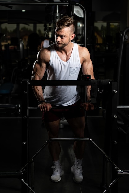 Hombre musculoso después del ejercicio descansando en el gimnasio