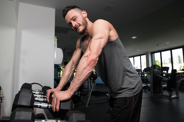 Hombre musculoso después del ejercicio descansando en el gimnasio