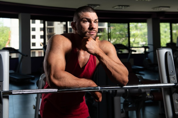 Hombre musculoso después del ejercicio descansando en el gimnasio