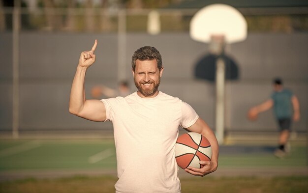 Hombre musculoso con entrenador deportivo de pelota de baloncesto o escuela deportiva de jugador de baloncesto