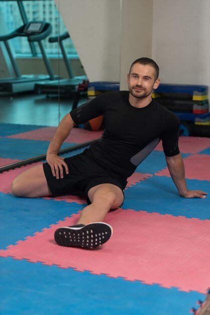 Hombre Musculoso Se Estira En El Piso En Un Gimnasio Y Flexionando Los Músculos Muscular Atlético Culturista Fitness Modelo