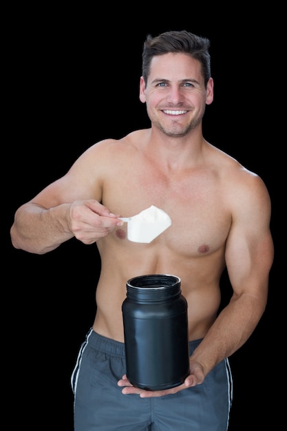 Hombre musculoso feliz recogiendo polvo de proteína