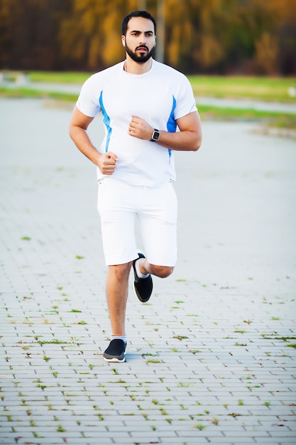 Hombre musculoso en forma corriendo fuera del concepto de fitness y deporte