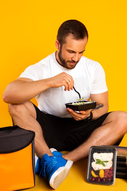 Hombre musculoso guapo con cajas de comida