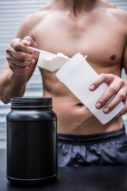 Foto hombre musculoso haciendo cóctel de proteína