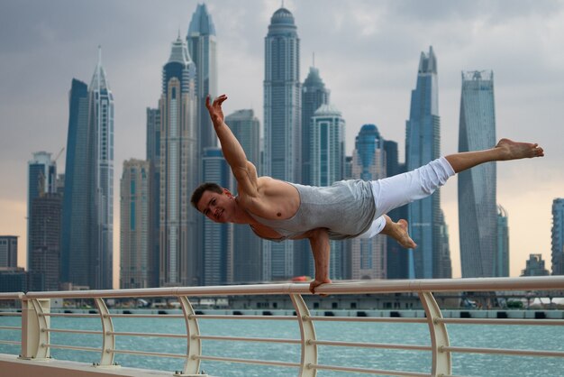 Hombre musculoso haciendo ejercicio en la calle con paisaje urbano de rascacielos en Dubai. Concepto de estilo de vida saludable y moderno.