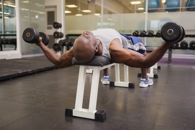 Hombre musculoso haciendo ejercicio con pesas