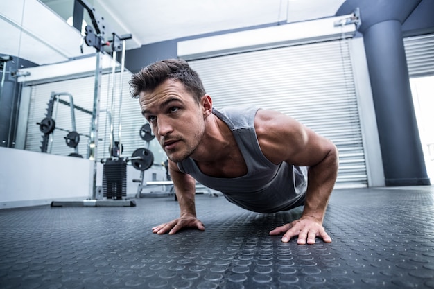 Foto un hombre musculoso haciendo flexiones