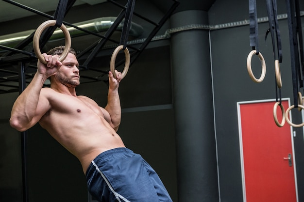 Hombre musculoso haciendo gimnasia de anillo