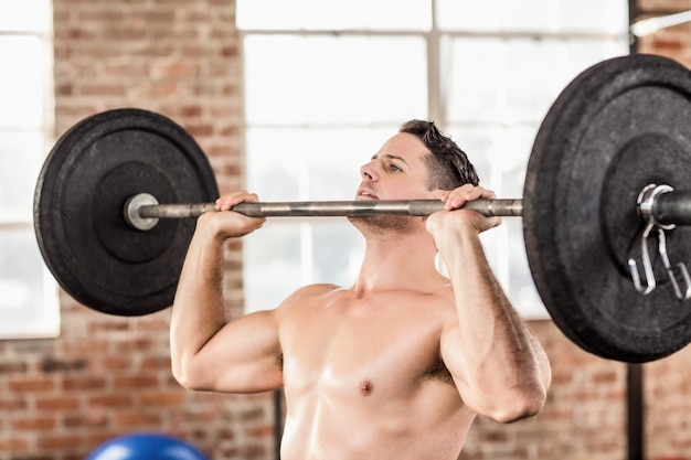 Hombre musculoso haciendo levantamiento de pesas en crossfit