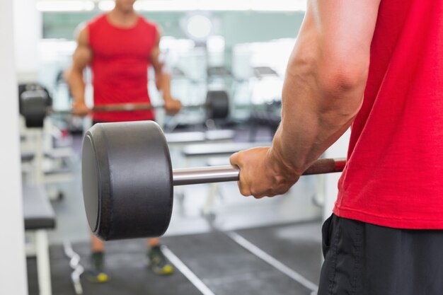 Foto hombre musculoso, levantamiento, barra, en, gimnasio