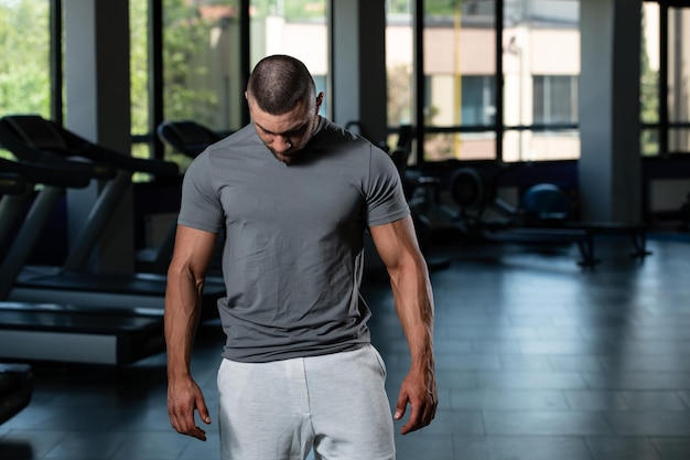 Hombre musculoso posando en camiseta gris