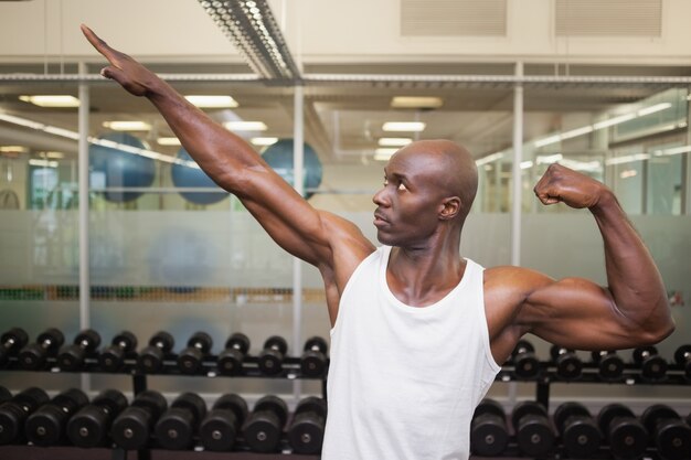 Hombre musculoso posando en el gimnasio