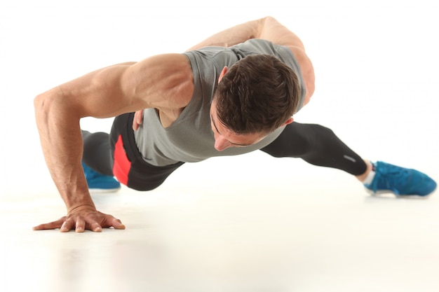 Hombre musculoso en ropa deportiva aislado en blanco