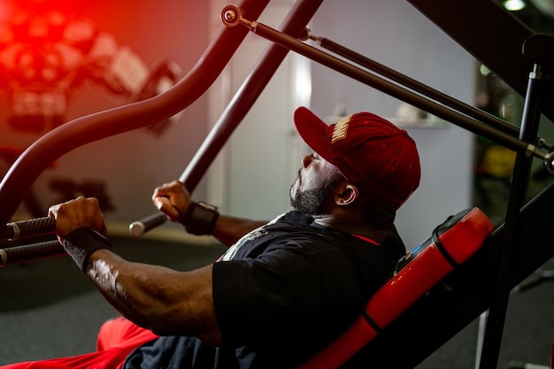 Hombre musculoso en ropa deportiva entrenando duro Culturista guapo joven trabajando en el gimnasio