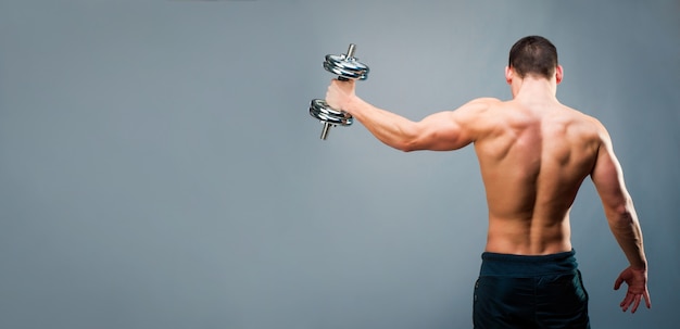 Hombre musculoso sobre fondo gris