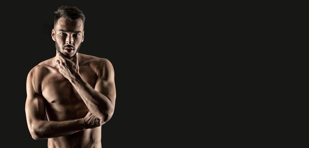 Foto el hombre musculoso toca la piel después de afeitarse aislado en una foto de estudio de fondo negro del hombre musculoso