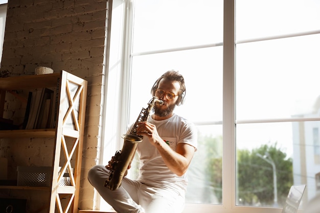 Hombre músico caucásico durante el concierto en línea en casa aislado y en cuarentena,