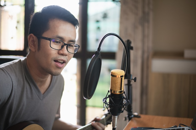 Hombre músico grabando música en el estudio de música en casa