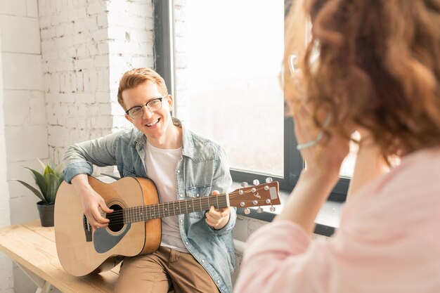 Hombre músico con guitarra cantando para su novia