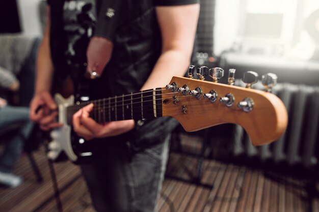 Hombre músico tocando el bajo en estudio