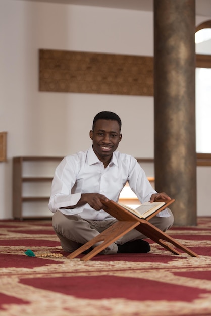 Hombre musulmán africano negro está leyendo el Corán
